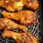Chicken wings in an air fryer basket.