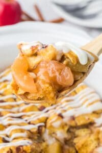 Cinnamon roll casserole being scooped up with a spoon.