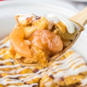 Cinnamon roll casserole being scooped up with a spoon.
