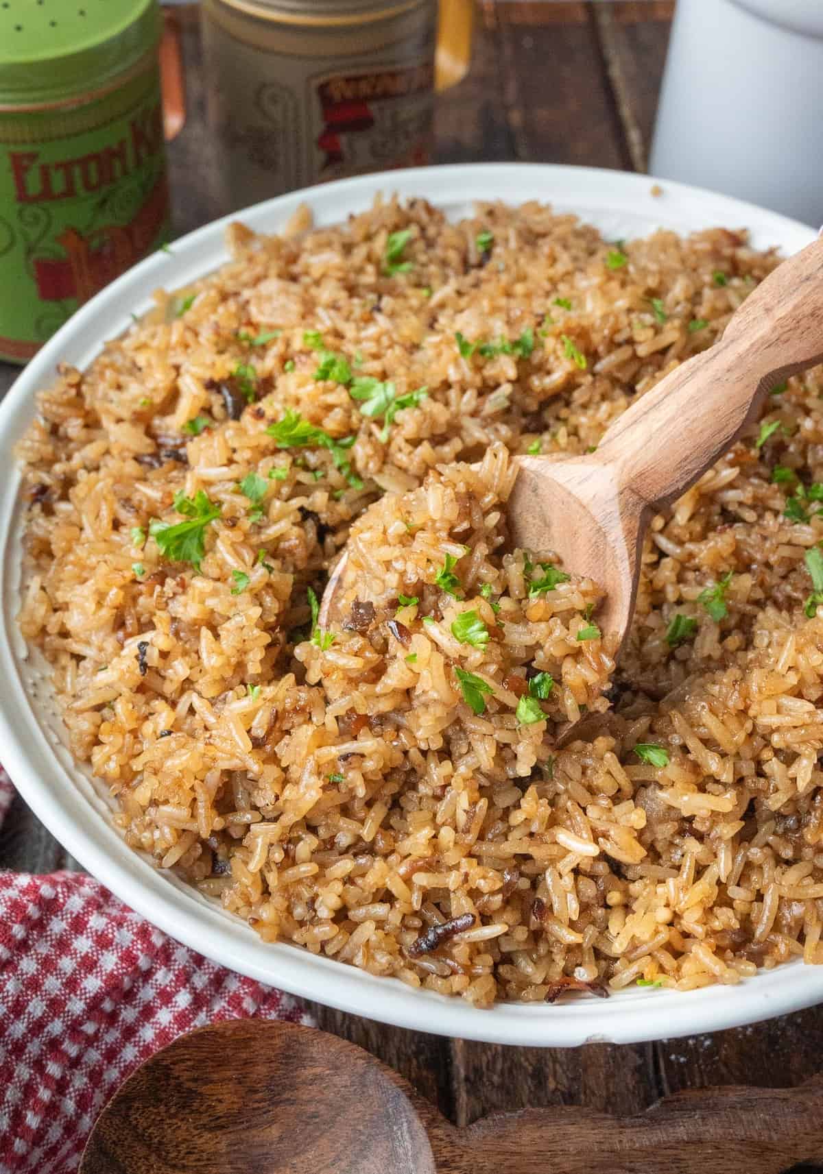 A spoon scooping up a bite of baked rice.