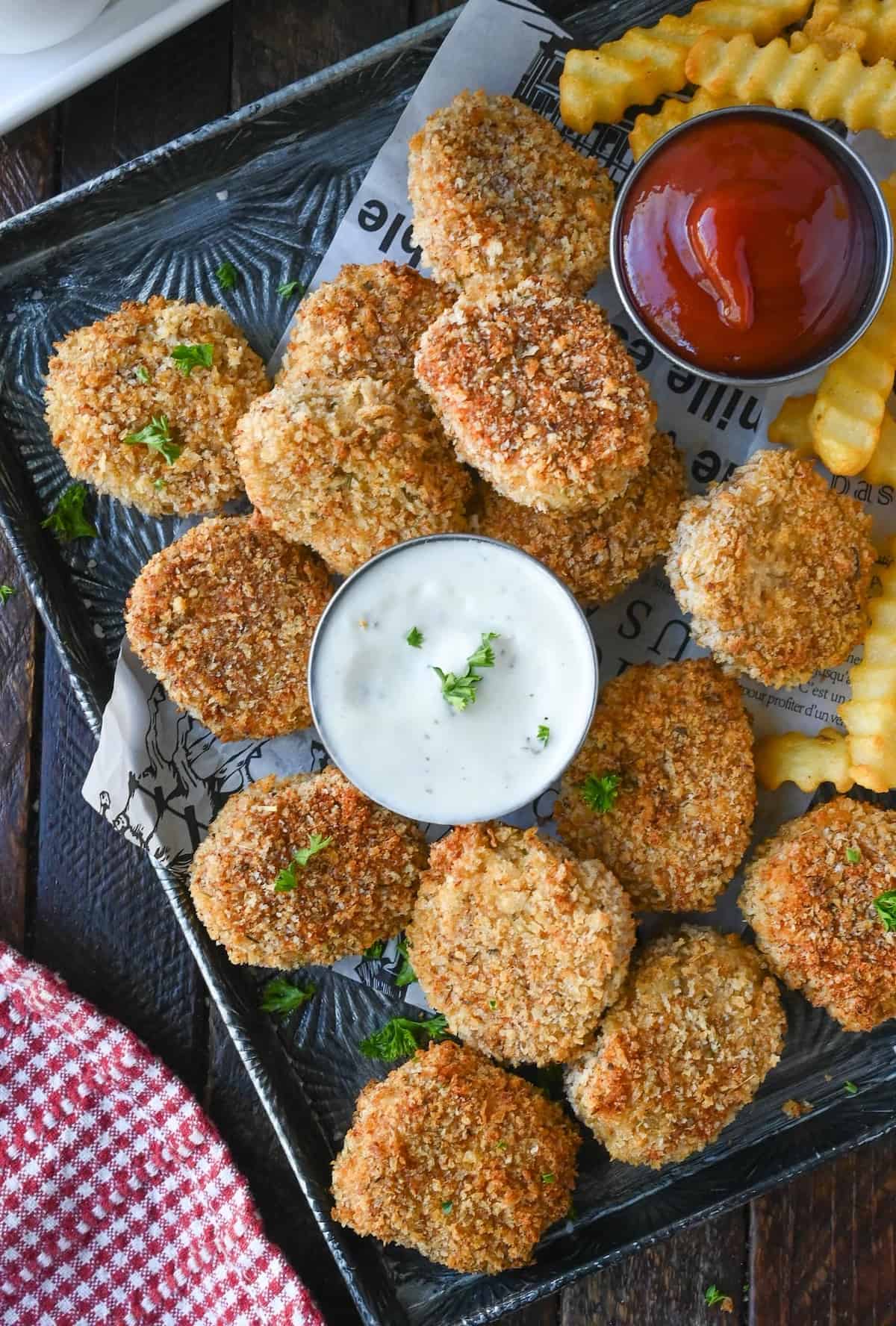 A plate of spicy chicken nuggets with dipping sauces.