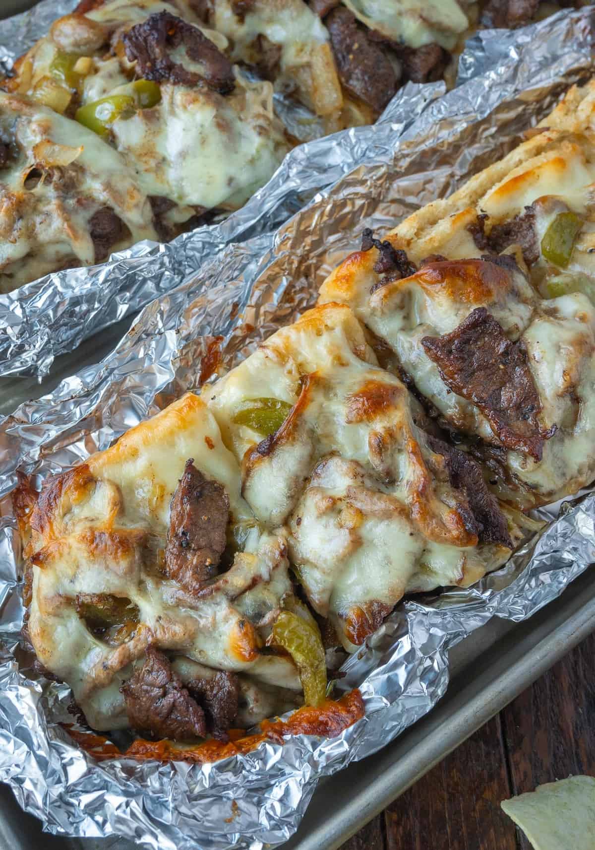 Philly cheesesteak pizza cut into slices.