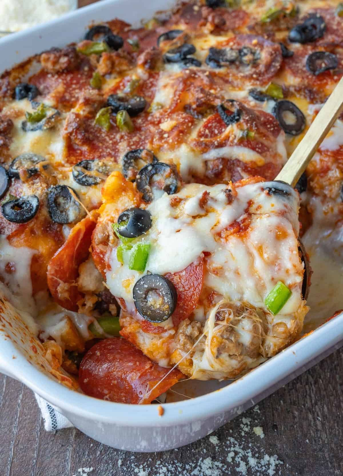 Close up of taking a scoop of bubble up pizza bake.