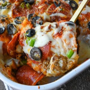 Close up shot of a spoon taking a scoop of bubble up pizza casserole.