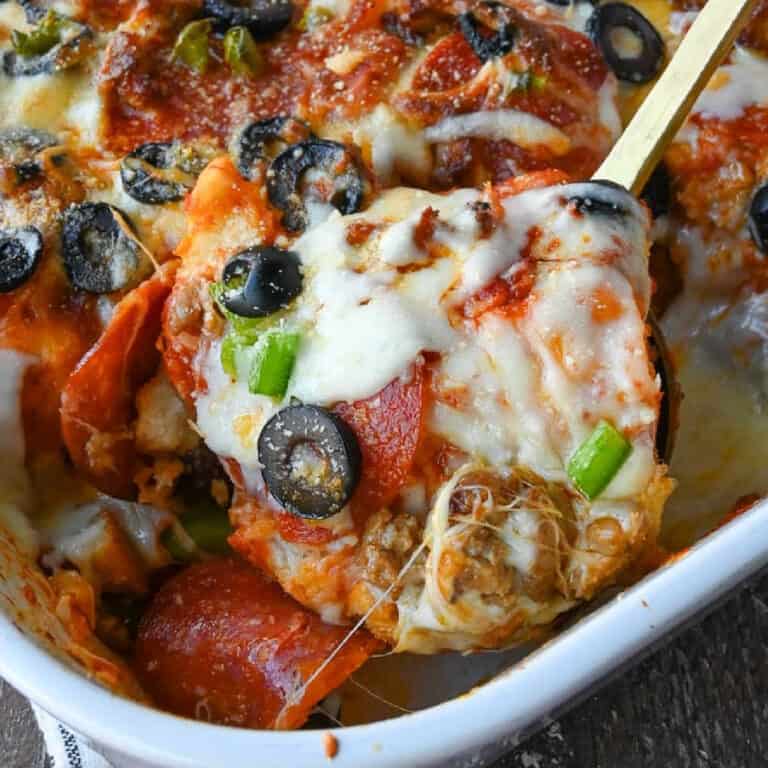 Close up shot of a spoon taking a scoop of bubble up pizza casserole.
