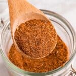 A wooden spoon scooping out some taco seasoning.