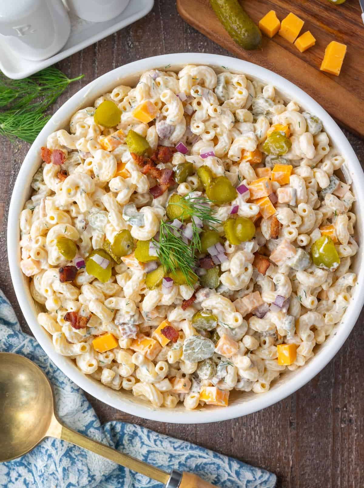 Dill pickle pasta salad in a white serving bowl.