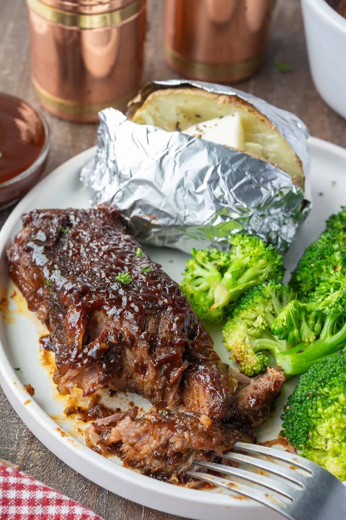 Boneless beef rib on a plate with potato and broccoli.