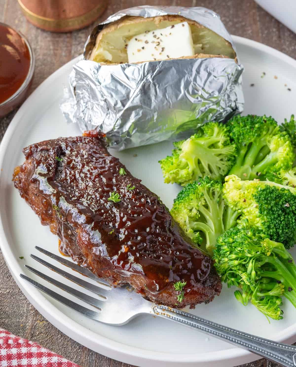 Boneless beef rib on a plate with potato and broccoli.