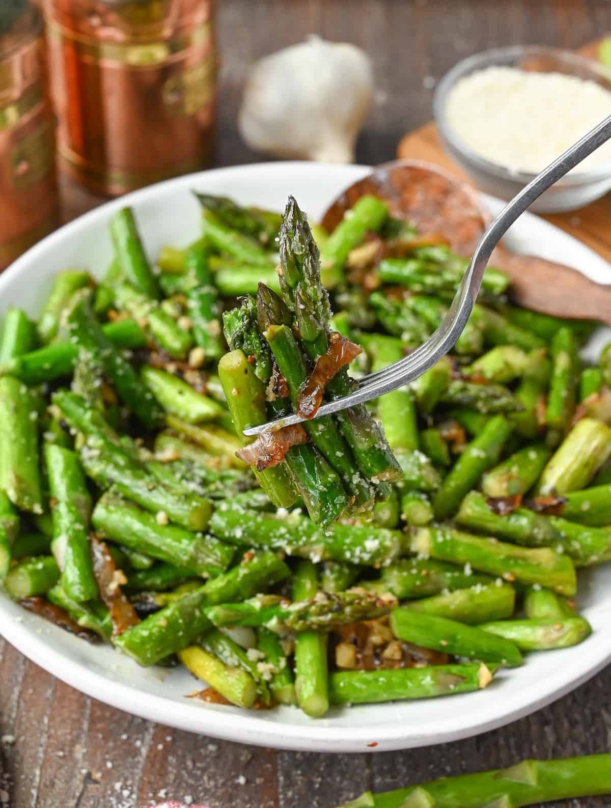 A fork picking up a bite of asparagus.