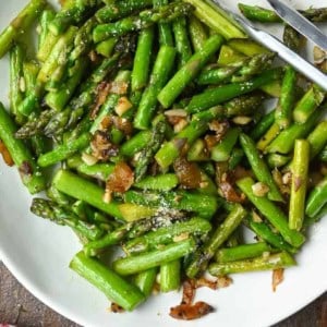 Pan fried asparagus on a white plate.