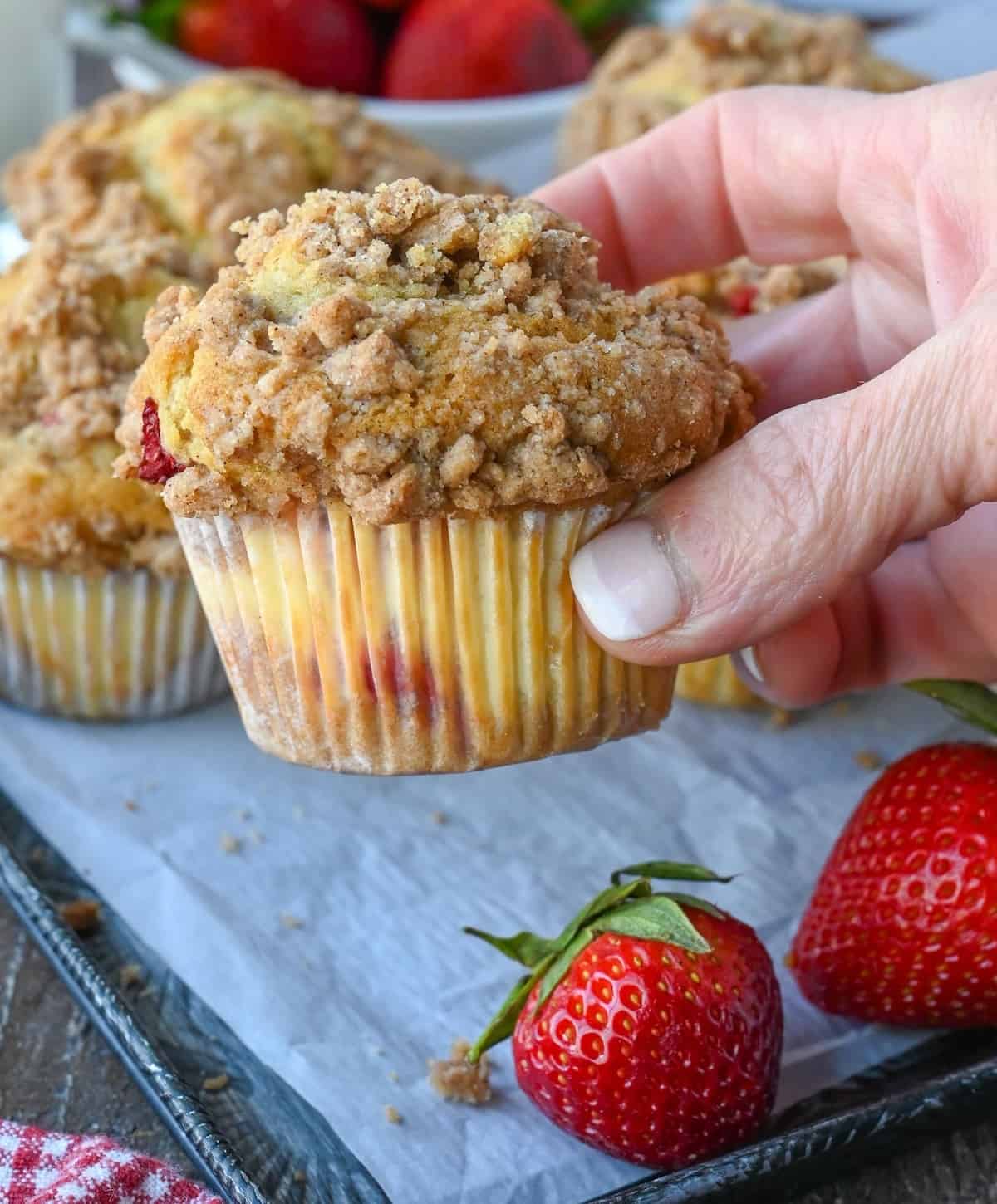 Strawberry cheesecake muffin being picked up.