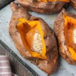 Closeup of an air fryer baked sweet potato with melted butter.