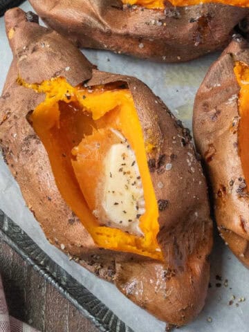 Closeup of an air fryer baked sweet potato with melted butter.