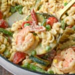 Close up of a spoonful of pasta primavera with shrimp.