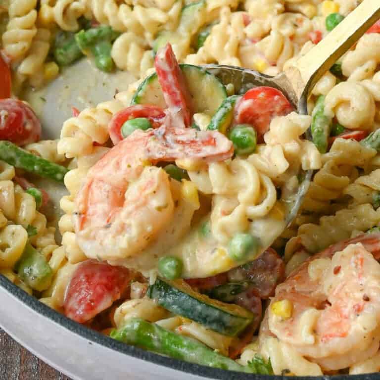 Close up of a spoonful of pasta primavera with shrimp.