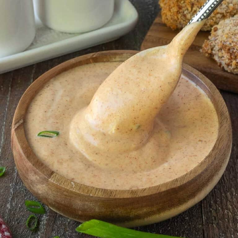 A small spoon scooping out some yum yum sauce.
