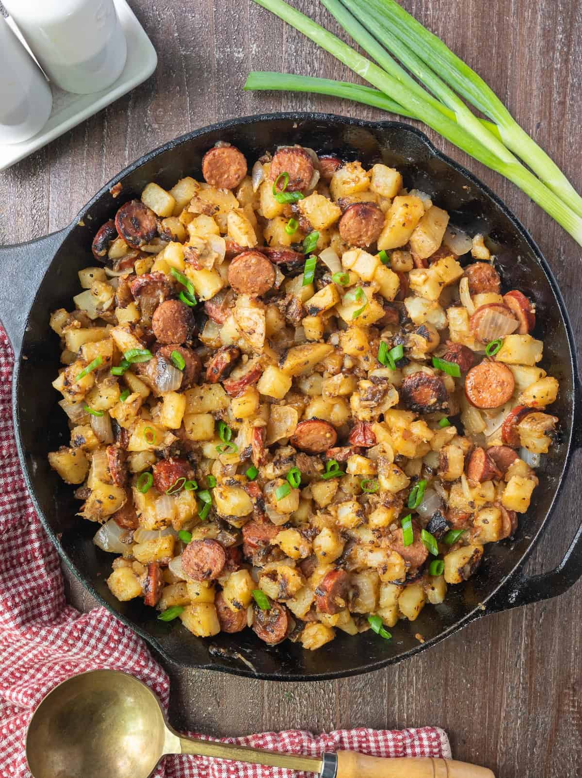 Southern fried potatoes in a skillet with sausages.