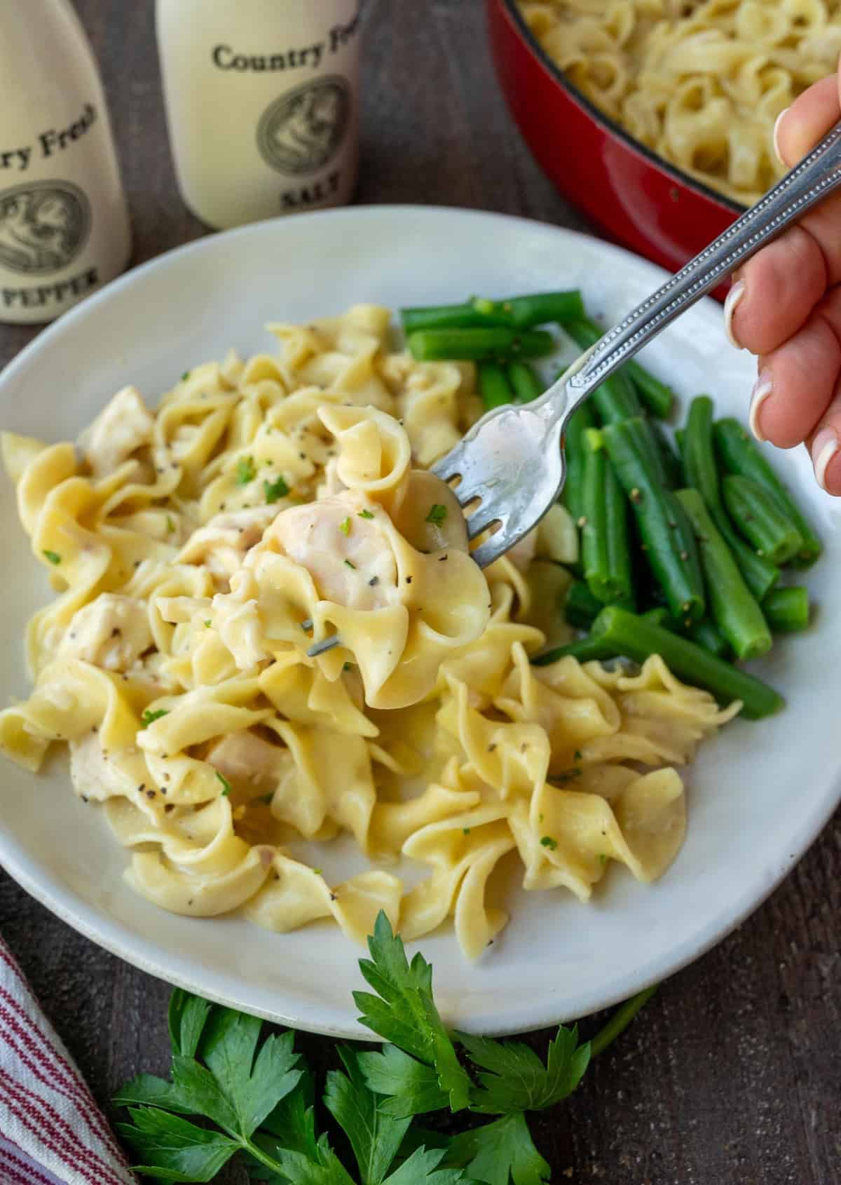 Lifting up a bite with chicken noodle skillet with a fork.