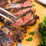 A fork picking up a slice of coffee rubbed steak.