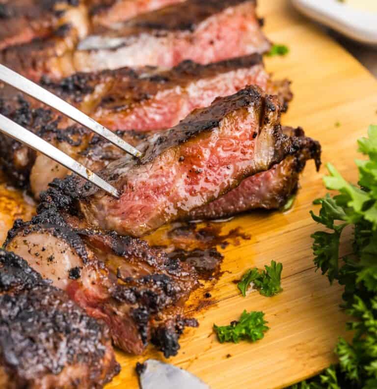 A fork picking up a slice of coffee rubbed steak.