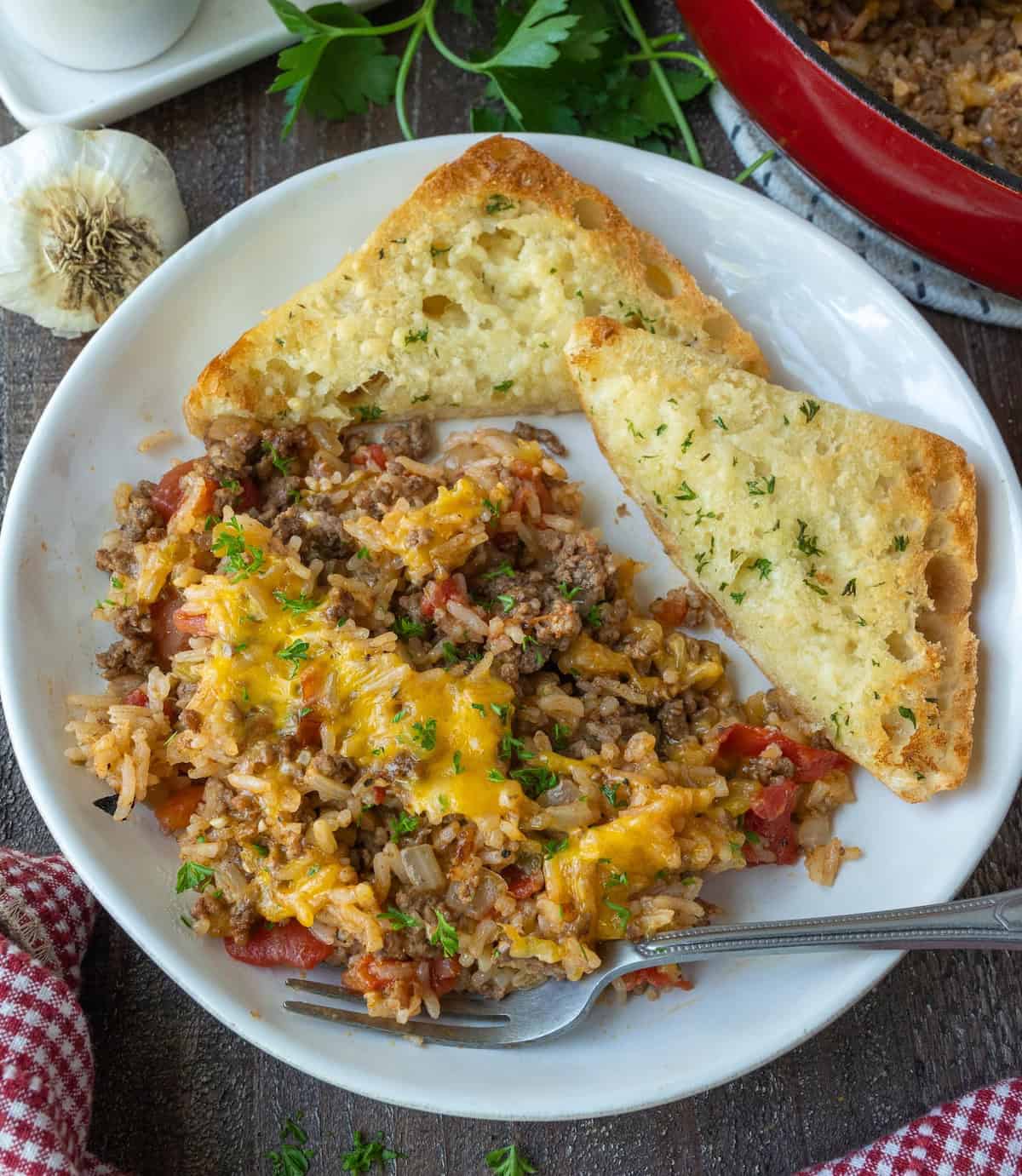 Ground beef and rice on a plate with garlic bread.