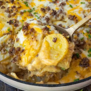 A serving spoon scooping up some hamburger potato casserole.