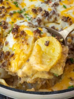 A serving spoon scooping up some hamburger potato casserole.