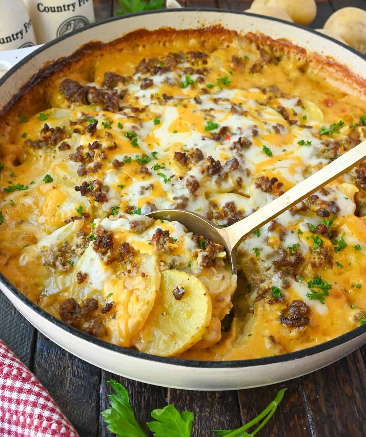 A serving spoon scooping up some hamburger potato casserole.