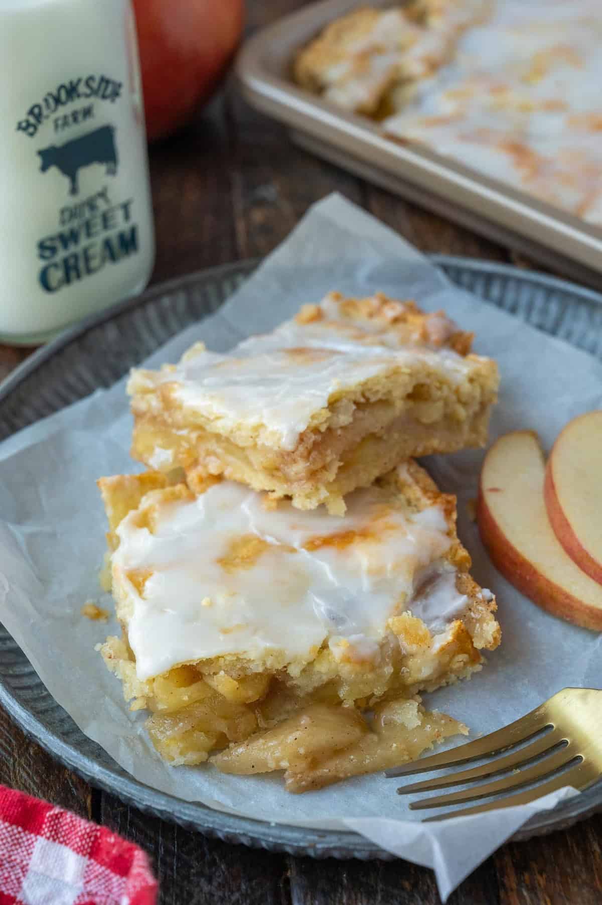 Apple pie bars on a plate with a fork.