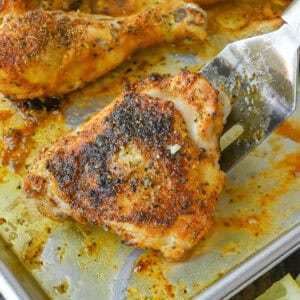 Close up of baked lemon pepper chicken on a baking sheet.