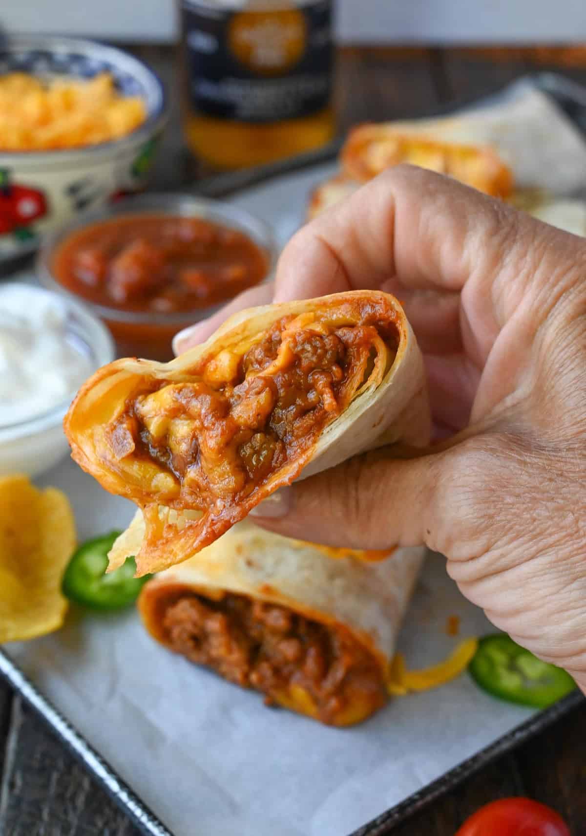 Holding up a chili cheese burrito.