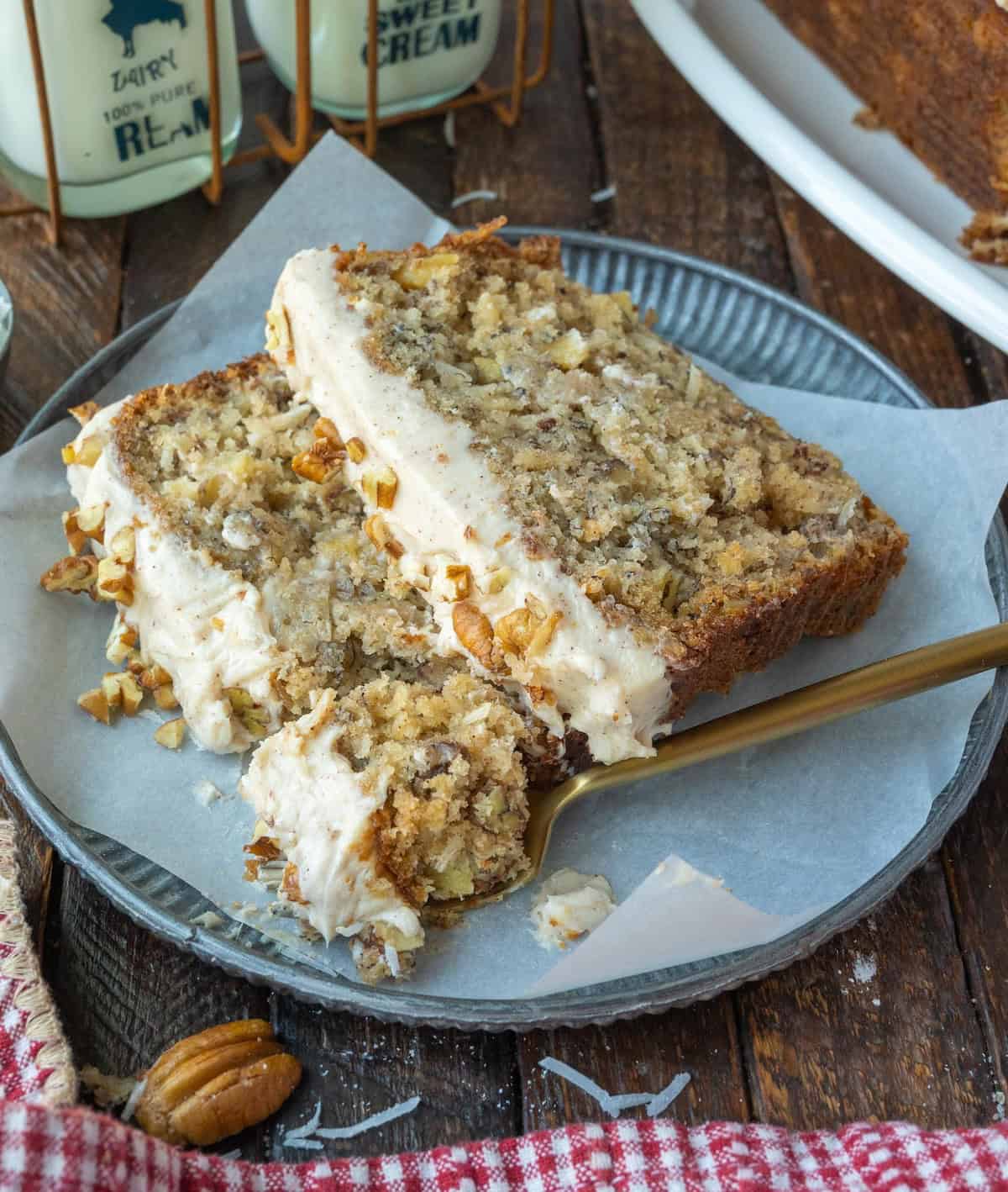 Two pieces of hummingbird bread on a plate with a golden fork.