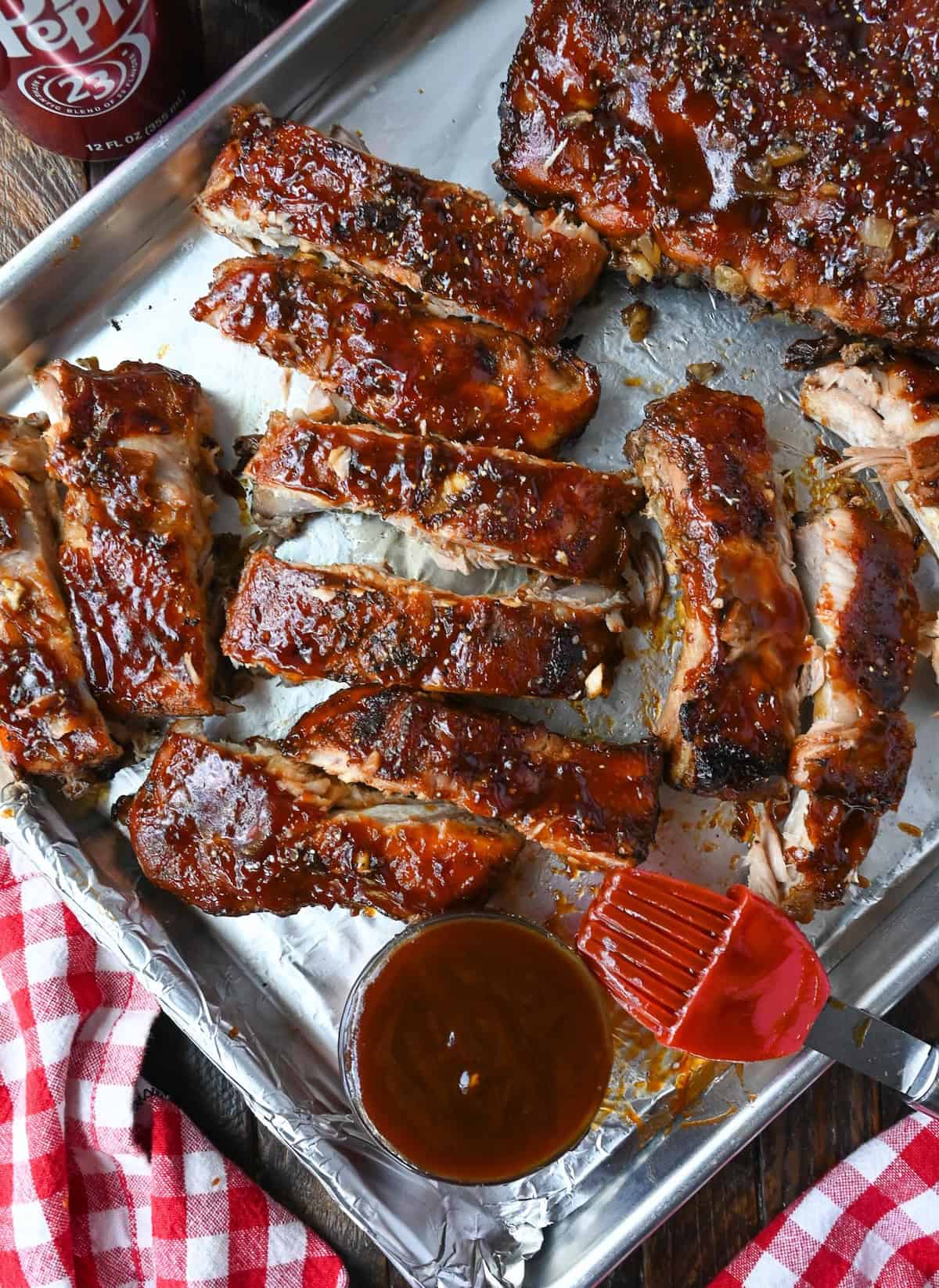 Pork ribs with bbq sauce on a baking sheet.