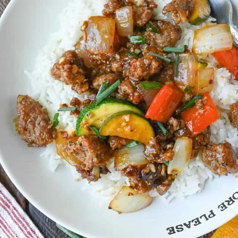 Close up of pork stir fry served over rice.
