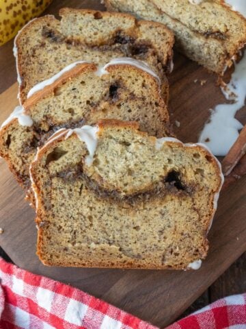 Several pieces of cinnamon banana bread on a cutting board.