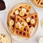 Banana waffles with syrup and banana slices.