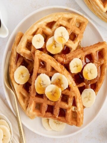 Banana waffles with syrup and banana slices.