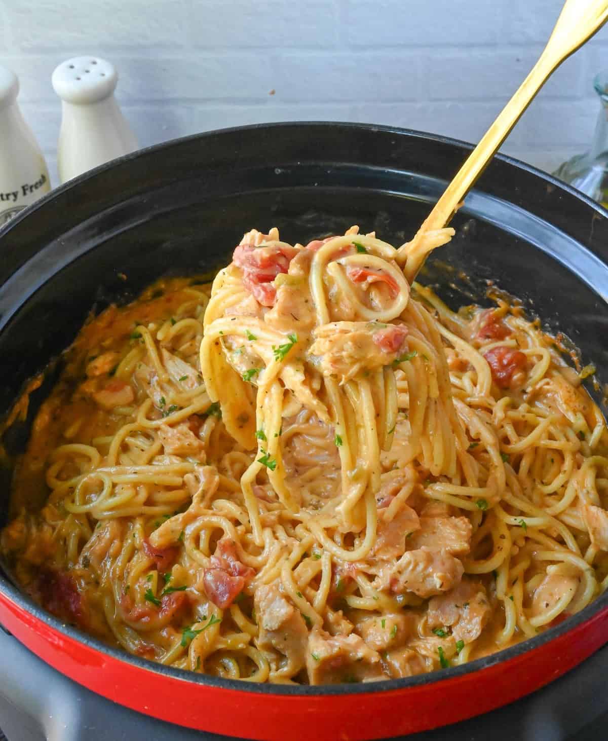 A ladle scooping up some chicken spaghetti.