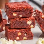 A stack of 3 red velvet brownies on a plate.