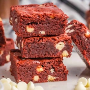 A stack of 3 red velvet brownies on a plate.