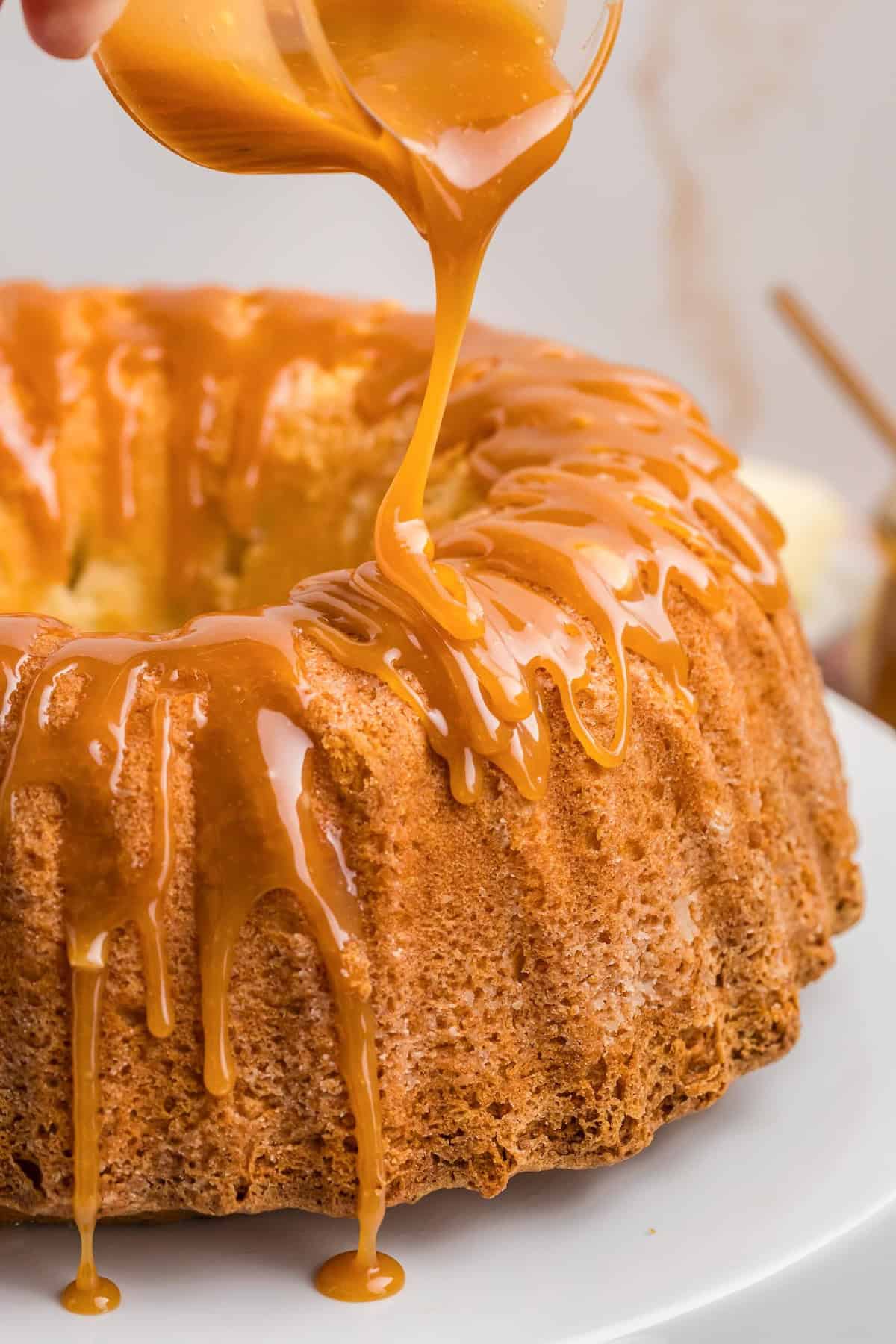 Drizzling bourbon caramel sauce over butter cake.