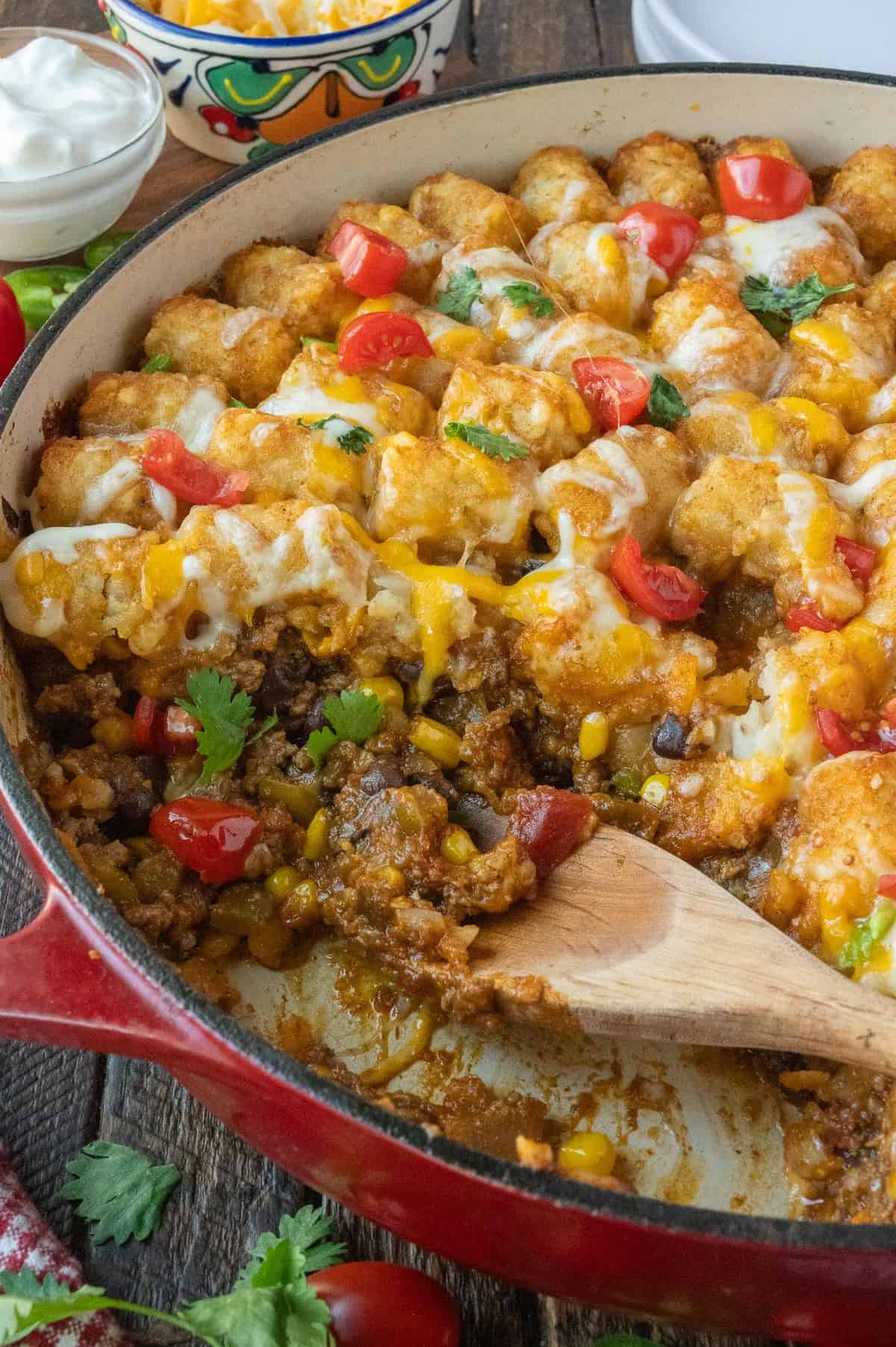 Side view of a casserole dish filled with mexican tater tots.