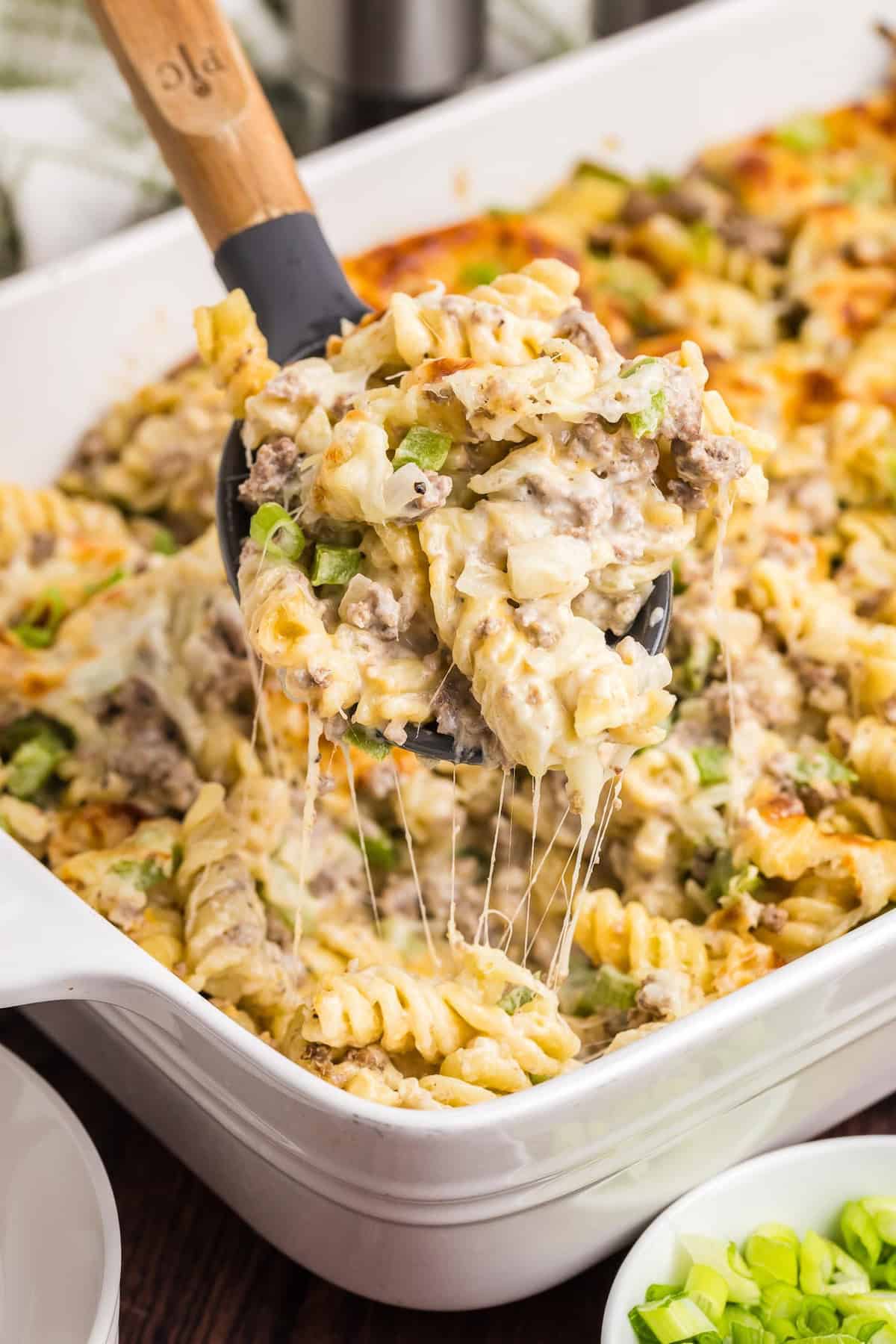 Philly cheesesteak casserole being scooped up with a spoon.