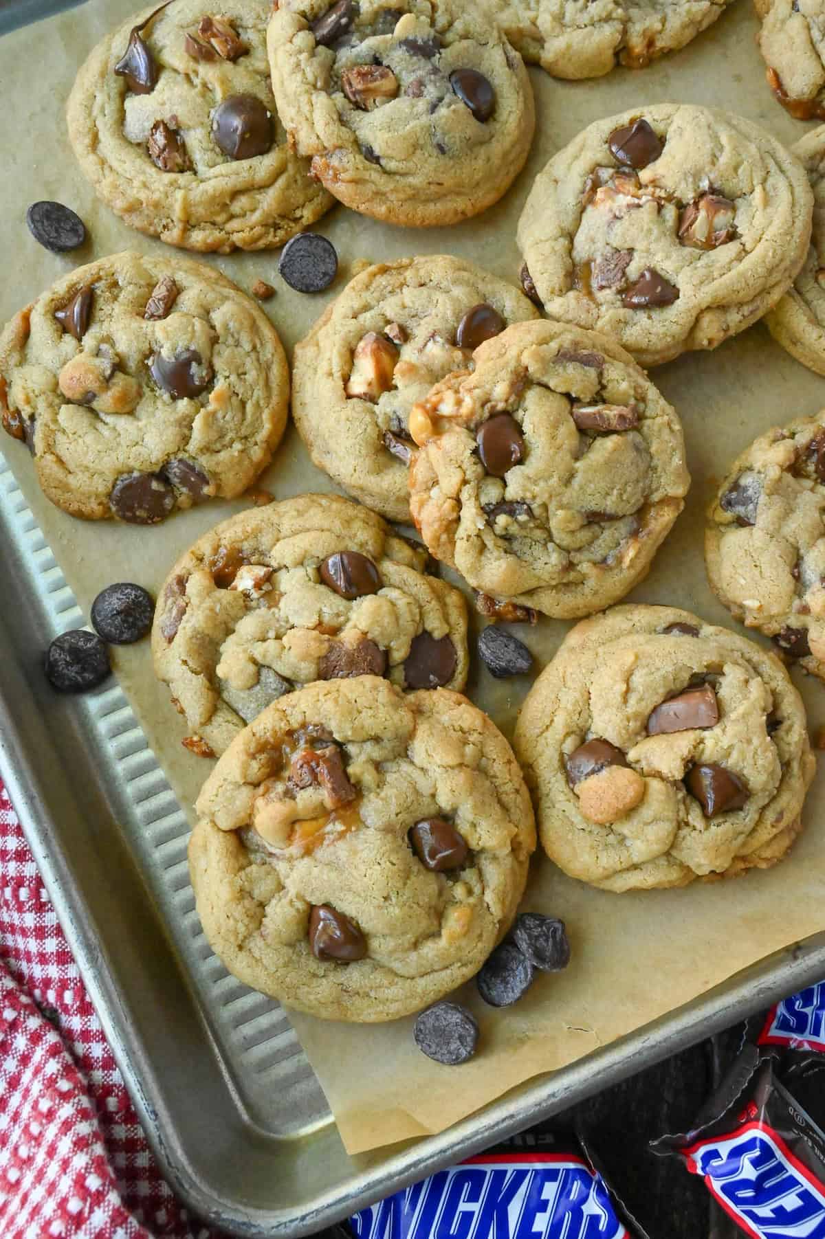 Snickers cookies on a plate with snickers bars.