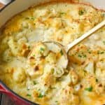 Cauliflower au gratin on a skillet with a spoon.