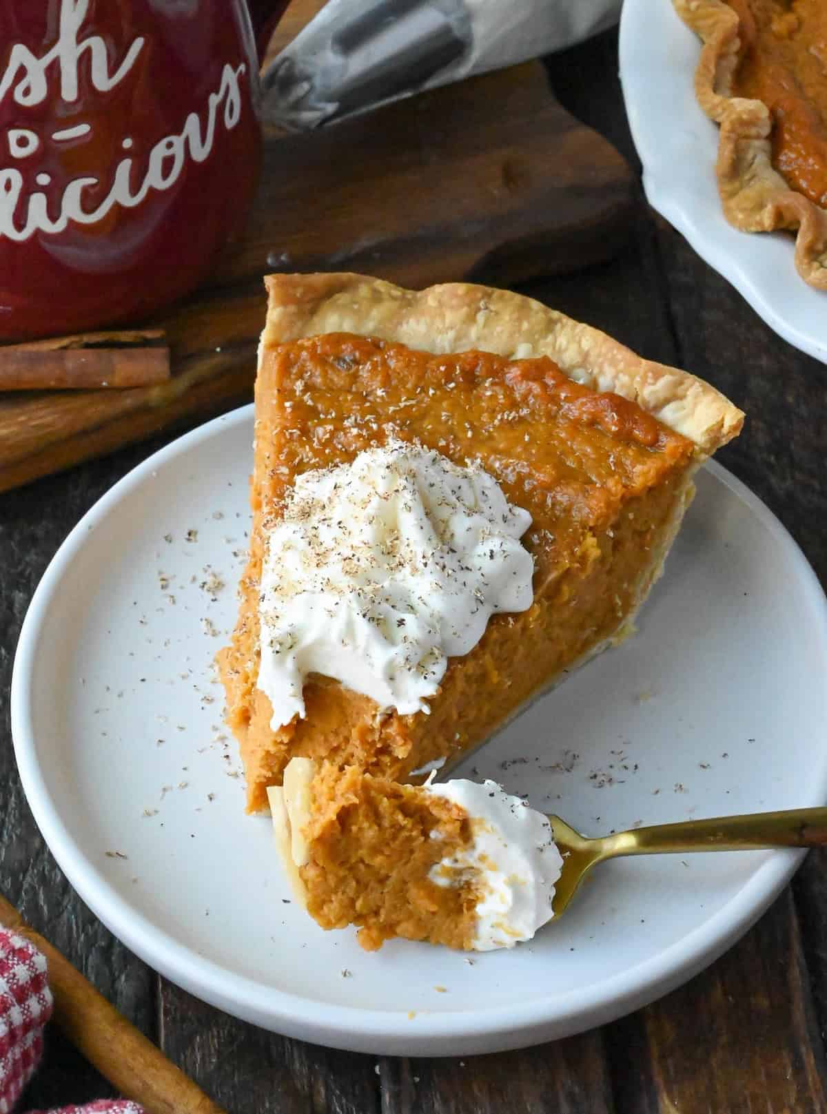 A slice of sweet potato pie on a plate with a fork.