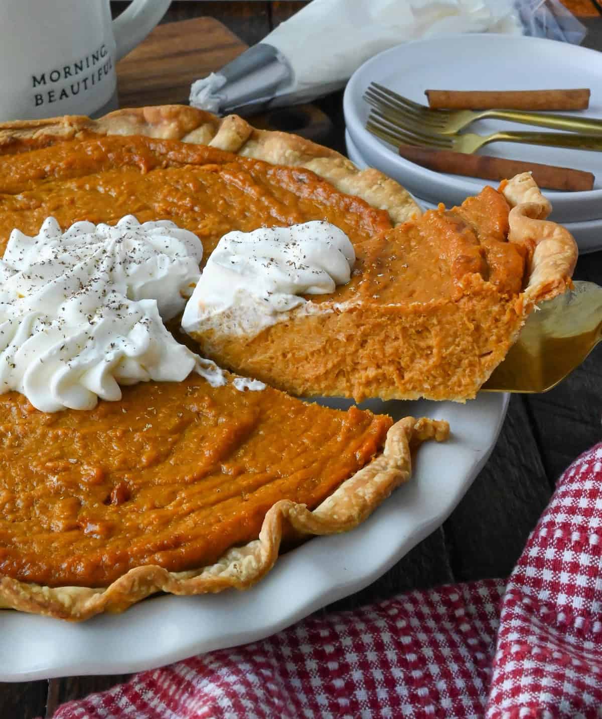 Sweet potato pie with a slice being cut out.