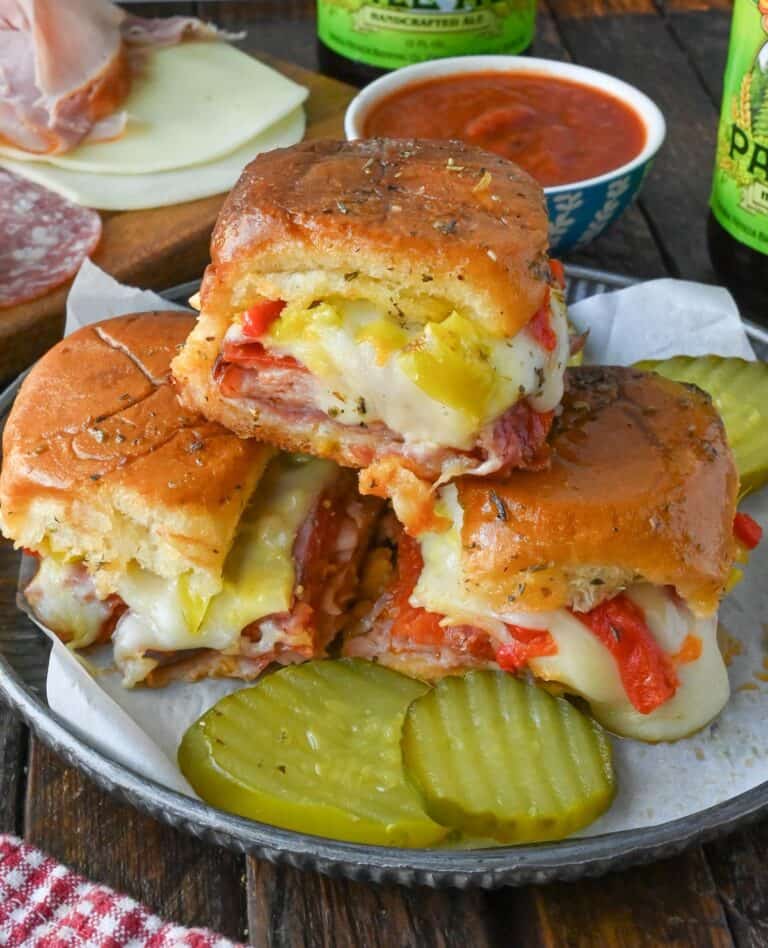 A plate with three stacked hot Italian sliders.