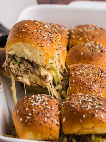 Lifting a slider from a casserole dish of other sliders.